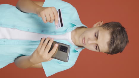 Vertical-video-of-Boy-shopping-with-credit-card.